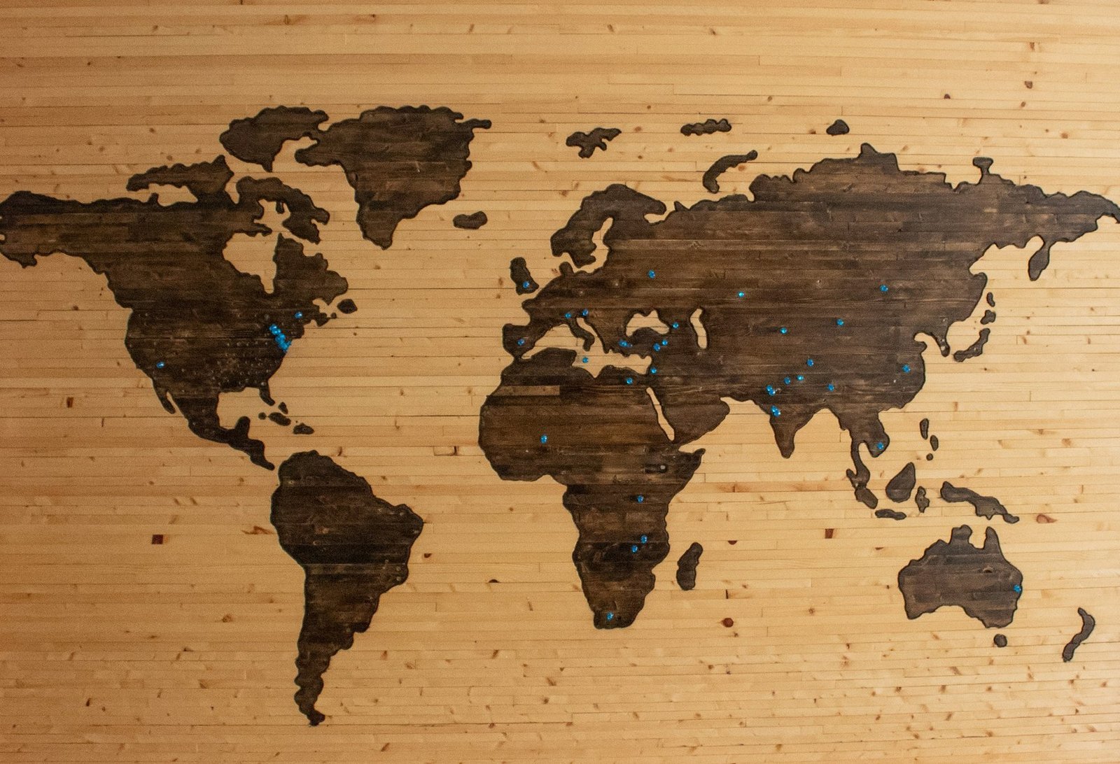 A wall-mounted world map marked with pins tracking field locations