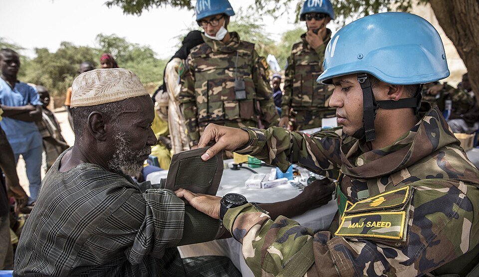 A Bangladeshi peacekeeper assists an elderly resident at a field clinic in northern Mali